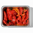 Roasted red sweet peppers in an aluminum tray, seasoned and charred, ready-to-eat deli side dish.